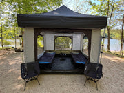 Compact Camper canopy tent insert attached to Compact Shelter at a campsite, showing enclosed tent setup with built-in floor and gear inside.